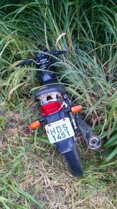 A motocicleta Honda Titan, de cor preta, foi abandonada no meio do mato.